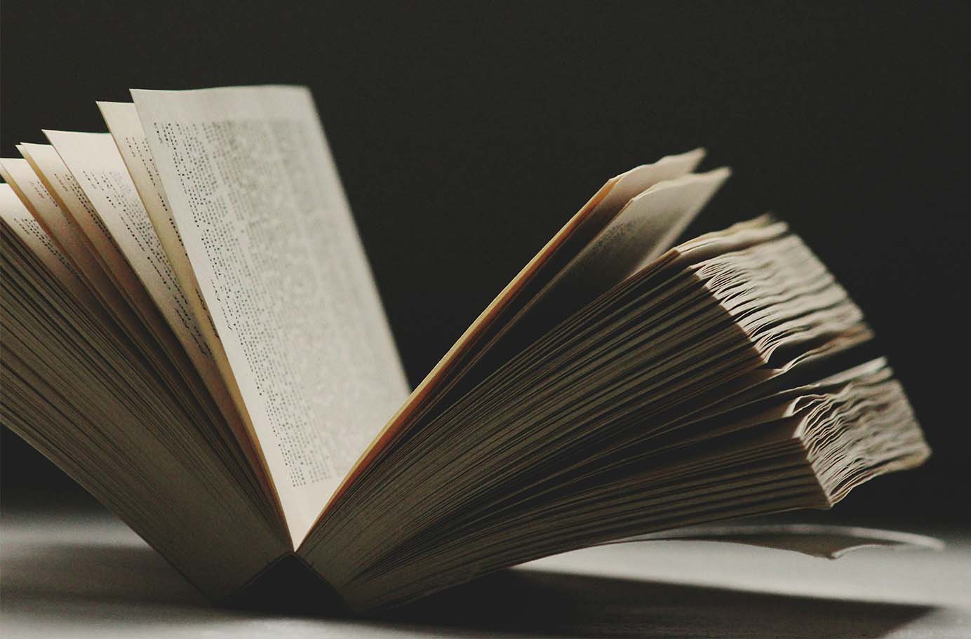 An image of book an open book in a dark room.